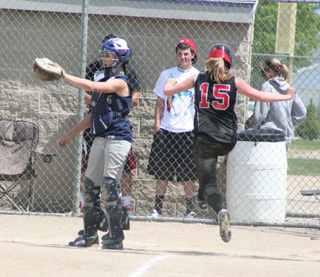 Kendall Schumacher jumps toward home plate as she is about to score the game-ending run in the championship game.