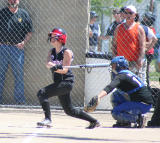 Megan Sigler watches the flight of the ball as she connected on the first pitch of the game for a triple and then scored when the throw in to third got away for an error.