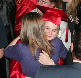 Betty Clark receives a hug from a well-wisher after graduation.