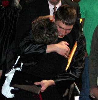 Patty Hinkelman gives Seth Guyer a hug after graduation.