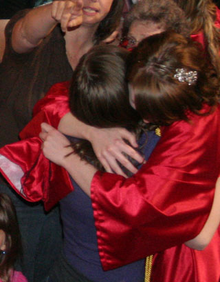 A grad gets a congratulatory hug. We think it's Kayla Johnson.