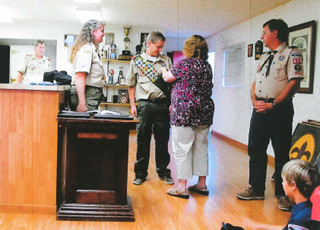 Laurie Karel pins her son Mike during Mikes Eagle Scout ceremony as Scoutmaster Shari Chaffee, left and his father Dan Karel look on. Photo courtesy of Jane Burgess.