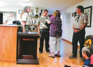 Laurie Karel pins her son Mike during Mikes Eagle Scout ceremony as Scoutmaster Shari Chaffee, left and his father Dan Karel look on. Photo courtesy of Jane Burgess.