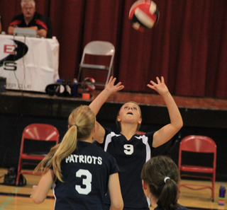 Brooke Schumacher sets the ball in the Genesee match. In front of her are her sister Kayla, 3, and Nicole Frei.