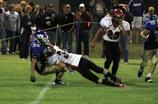 McCoy Hale tackles a Genesee ballcarrier for a loss. At right is Levi Lustig.