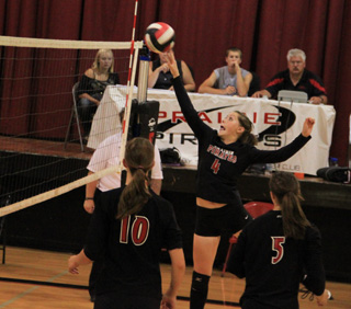 Megan Sigler tips the ball over against Summit as Tyler Workman and Monica Lustig watch.