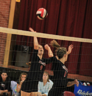 Tanna Schlader is about to spike the ball against Summit as Leah Holthaus makes a fake.