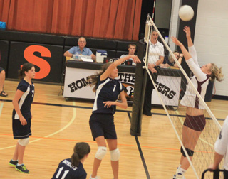 Savanah Prigge gets a spike past Kamiah's Shelby Cloninger in the championship match. At left is Megan Rehder and in the foreground is Nicole Frei.