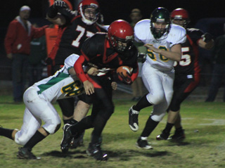 Cody Schumacher carries the ball for some of his team high 125 yards. Behind him is Devon Watton with Josh Roeper to the right.