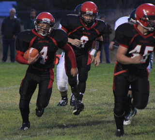 Damian McWilliams carries the ball on a sweep. Blocking for him is Garrett Schmidt with Troy Lorentz behind him.