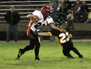 Levi Lustig pushes his way past a would-be tackler on the way to the game’s first touchdown.