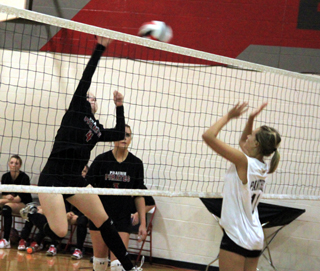 Megan Sigler goes for a kill against Asotin as MeShel Rad watches.