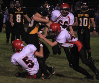 Tim Frei, 5, and Kade Perrin tackle a Timberline ballcarrier. In the background is Seth Chaffee.