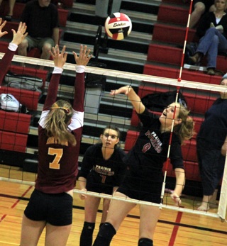 Tanna Schlader spikes the ball against Dayton as Sam Poxleitner watches.