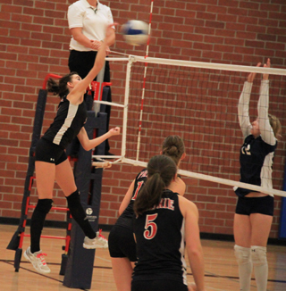 Sam Poxleitner hits the ball against Grangeville at Genesee. Also shown are Tyler Workman and Monica Lustig, 5.