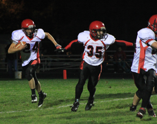 Justin Schmidt carries the ball on a sweep to the right. Cody Schumacher, 35, and McCoy Hale, right, provide the lead blocking.
