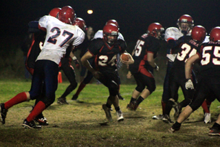 Justin Schmidt runs through a hole created by Prairie blockers. Shown to his right are Josh Zigler, 75, Cody Schumacher and Josh Roeper.