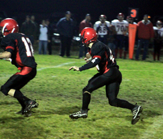 Kade Perrin runs with the ball after intercepting a pass. At left is Tim Frei.