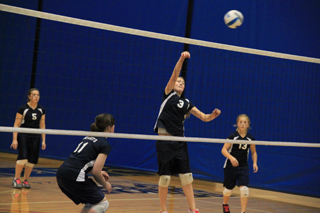 Kayla Schumacher spikes the ball against Timberline at District. Also shown from left are Rachael Frei, Nicole Frei and Nicole Wemhoff.