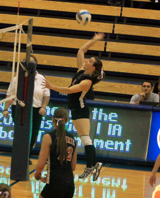 Monica Lustig goes up for a spike against Kendrick. #22 is MeShel Rad.