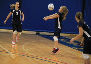 Nicole Wemhoff digs a serve in the Nezperce match on Saturday. She is flanked by her cousins Kayla and Brooke Schumacher.