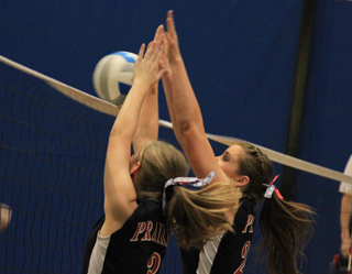 Tanna Schlader and MeShel Rad throw up a block against C.V. at District.