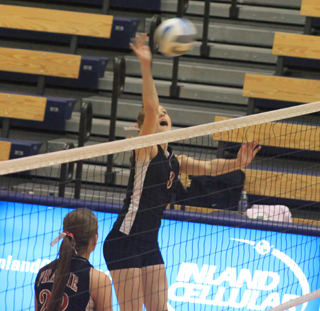 Tanna Schlader spikes the ball in the Kendrick match. At lower left is MeShel Rad.