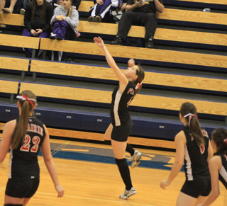 Megan Sigler goes up for a spike against Horseshoe Bend at State. At left is MeShel Rad and at right is Monica Lustig.