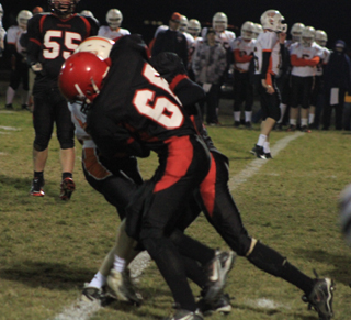 Seth Chaffee and an unidentified Pirate player tackle a Troy runner. Josh Roeper is in the background.