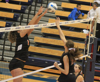 Tyler Workman tries to spike the ball past Hagerman's 6 foot plus middle blocker.