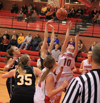 Megan Sigler goes after a rebound. Also shown are Kendall Schumacher, back to the camera, and MeShel Rad.