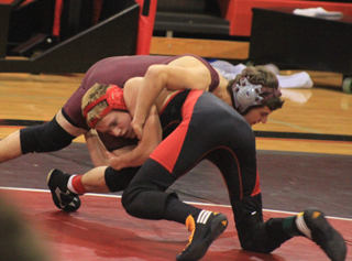Dally Ratcliff drives into Kamiahs Anthony Spradlin on his way to a win at the home meet Dec. 5.