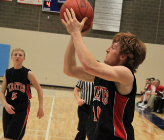 Troy Lorentz shoots for 2 of his career high 10 points. At left is Marcus Higgins.