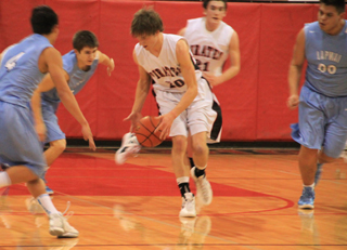 Justin Schmidt comes up with a loose ball against Lapwai. In back is Seth Chaffee.
