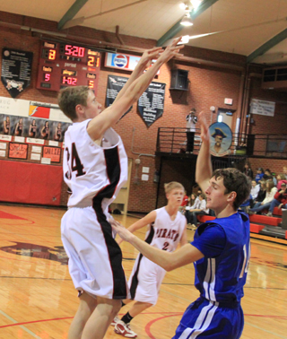 Lucas Arnzen goes up for a jump shot against Genesee. Rhett Schlader can be seen in the background.