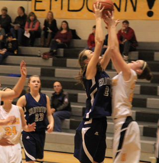 Savanah Prigge battles for a rebound against Highland. At left is Brooke Schumacher.