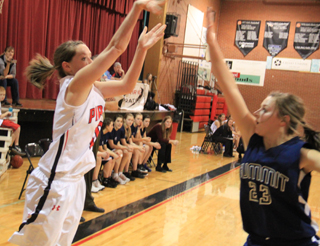 Megan Sigler puts up a 3-point shot against Summit as Brooke Schumacher gets a hand in her face.