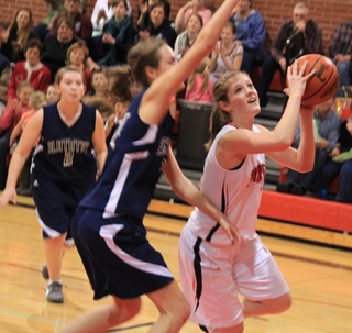 Tanna Schlader attempts to get a shot up past her cousin Savanah Prigge of Summit. In the background is Rachael Frei