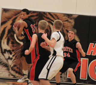 Tyler Hanerson comes down with a defensive rebound. Also shown are Rhett Schlader, back to the camera, and Lucas Arnzen.