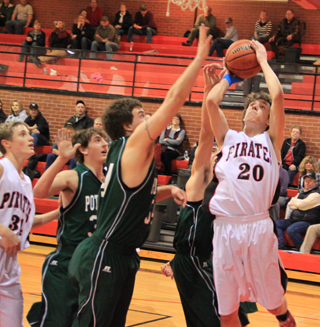 Justin Schmidt powers through the defenders for a lay-up against Potlatch. At left is Lucas Arnzen.