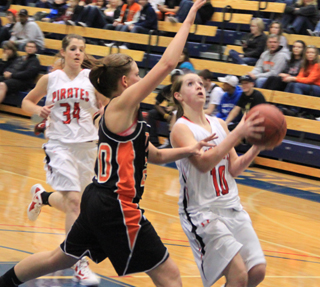 Megan Sigler goes for a lay-up against Troy as Shelby VonBargen trails on the play.