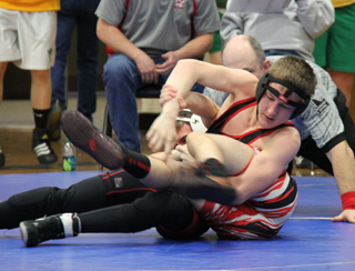 Alex Duman ties up the legs of Wallaces Mike Carey in the District Championship match. Photo by Pat McWilliams.