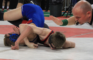 The referee is about to slap the mat for a pinfall as Alex Duman beats McCalls Casey Clark in the consolation semifinals.