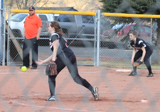 Megan Sigler lets fly with a pitch in the Prairie softball season opener at Kendrick. At right is third baseman Makenzie Rieman.