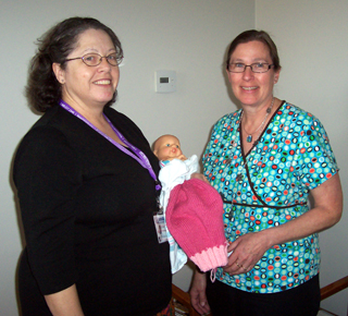Sr. Janet Barnard, RN and Barb Michels, RN showing off the their Labor Demonstration Doll. Photo provided by Cheri Holthaus.