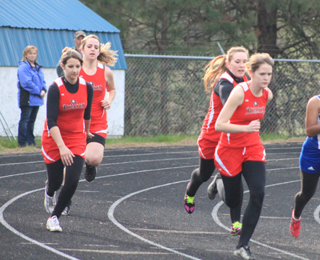 Prairie had 2 teams in the girls 4x100 relay and they were still close on the first handoff. At left Heidi Holubetz hands off to Beth Dinning and at right Keely Schmidt hands off to Claire Whitley.
