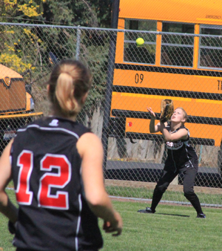 Taylor Nuxoll is about to make a catch in left field as rightfielder Kelsey Tidwell watches.