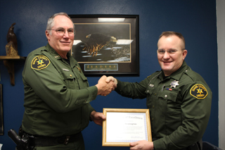 Sheriff Doug Giddings, left, presents Tom Remington with a certificate of excellence. See story below. Photo by Monica Walker.