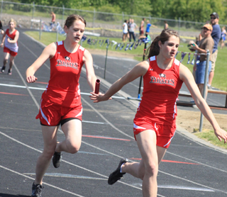 Claire Whitley hands off to Shelby VonBargen in the 4x200 relay which Prairie won.