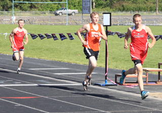 Peter Spencer, right, leads the 1600 at the halfway point while Justin Ross was running third. Ross passed the Troy runner in the final lap to finish 2nd while Spencer held on for first.